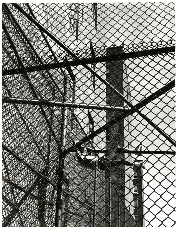 Image of a young person climbing a chain link fence