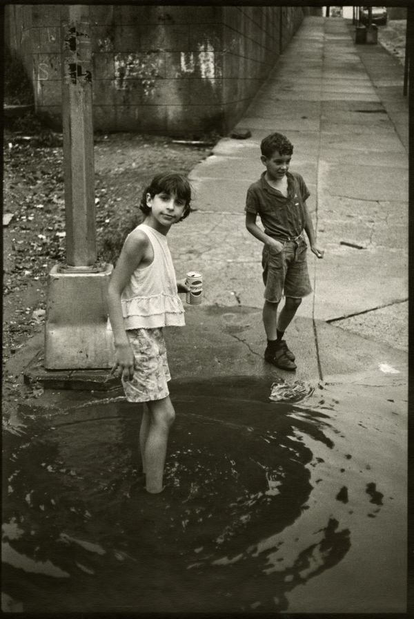 Image of two children playing in a muddle puddle.