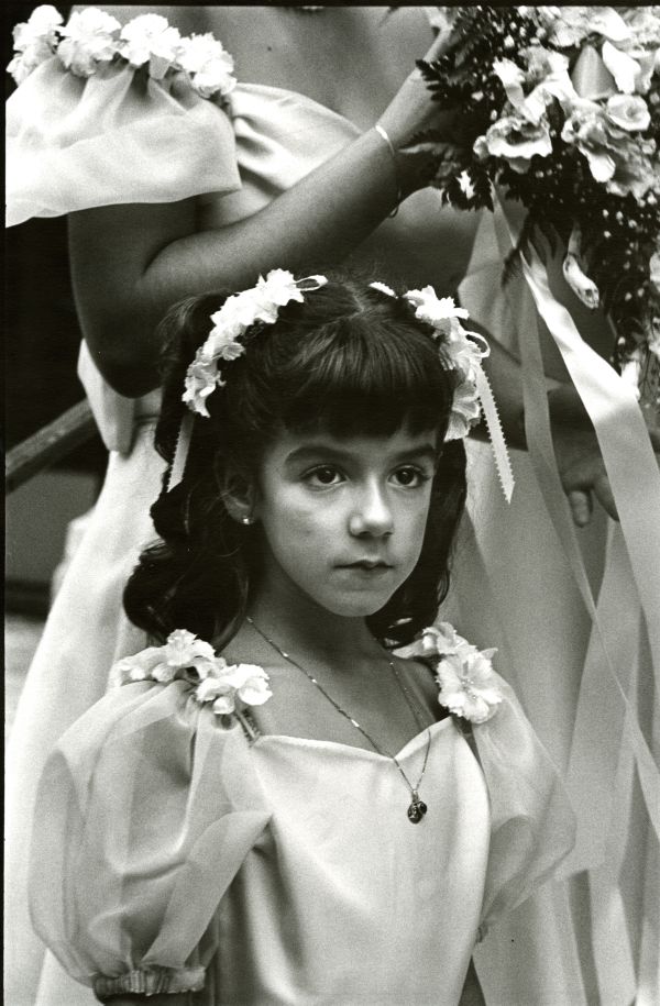 Image of a flower girl dressed in white at a wedding.