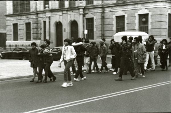 Image of several people  in a funeral procession.