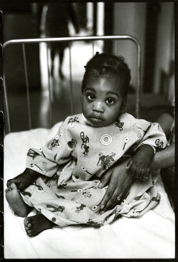 Image of a boy looking at camera in hospital gown.