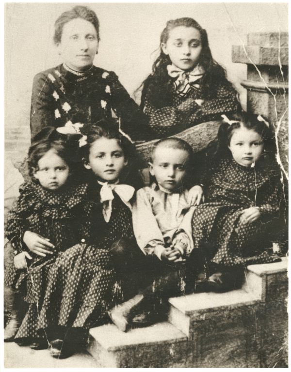 Image of five children sitting on steps around their mother.