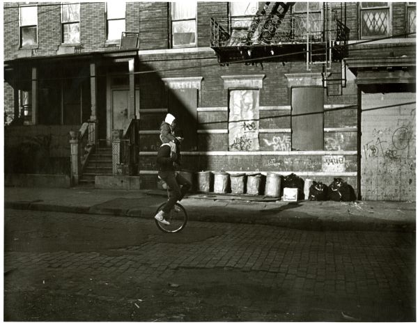 Image of boy and father riding on a unicycle.