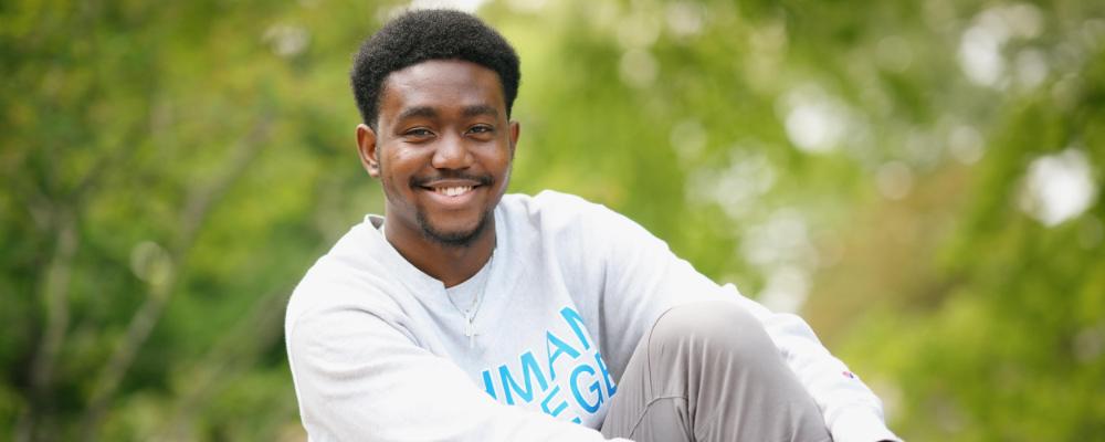 Lehman college student sitting and smiling