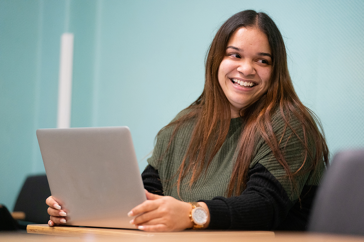 Photo of student with laptop smiling