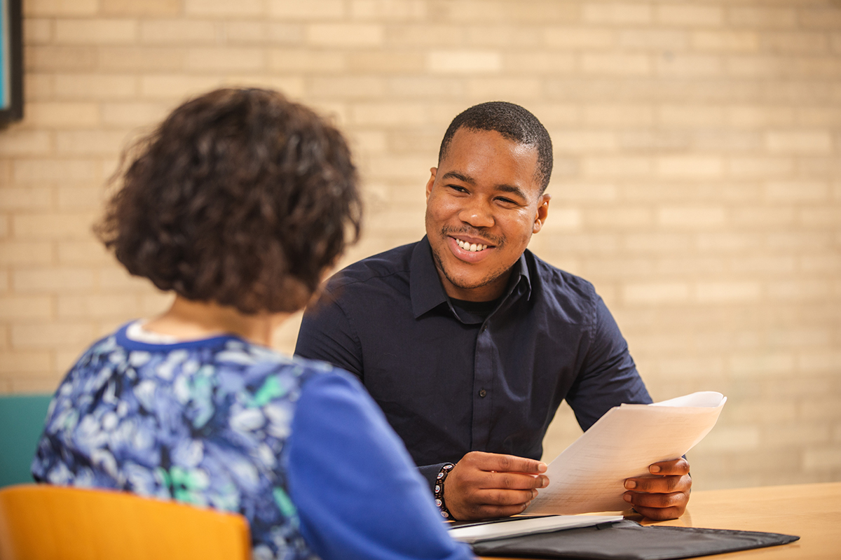 Photo of student talking to a staff member