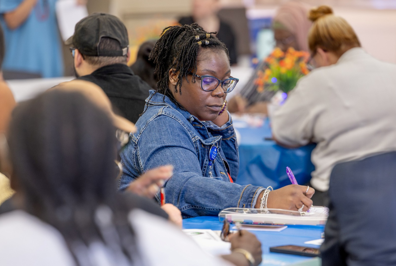 Photo of student writing in notebook during information session