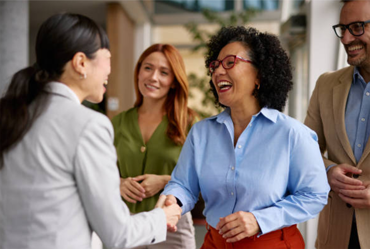 Diverse group of people smiling and greeting eachother
