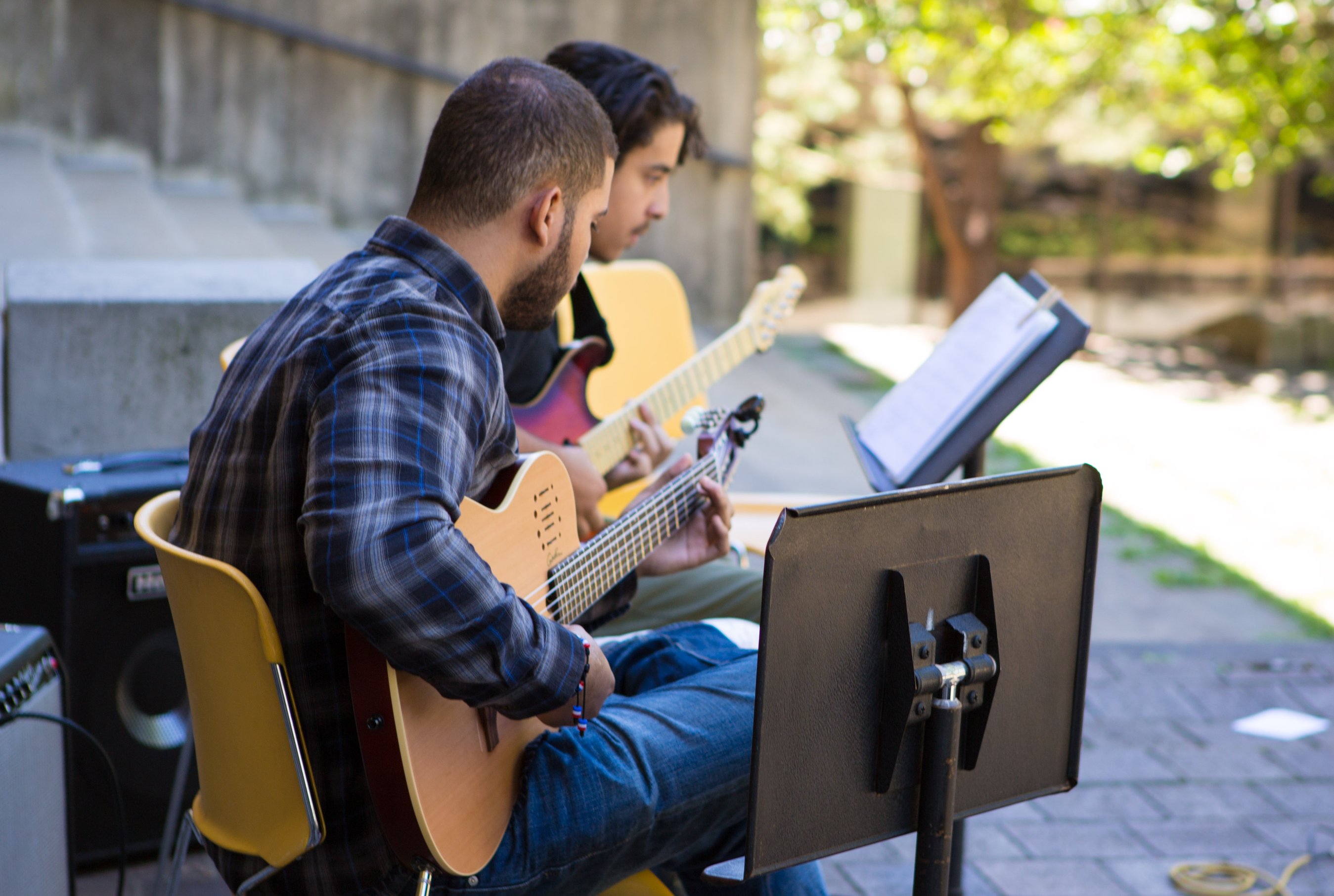 two people playing guitars
