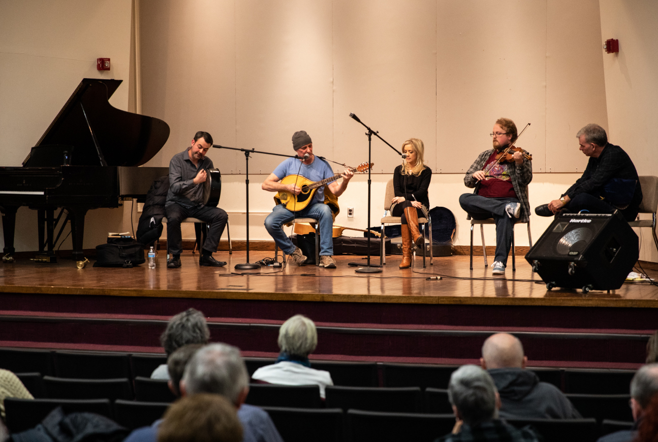 A quartet of musicians perform on a stage.