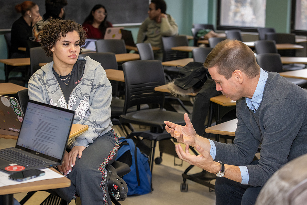 Photo of student talking to professor during a class