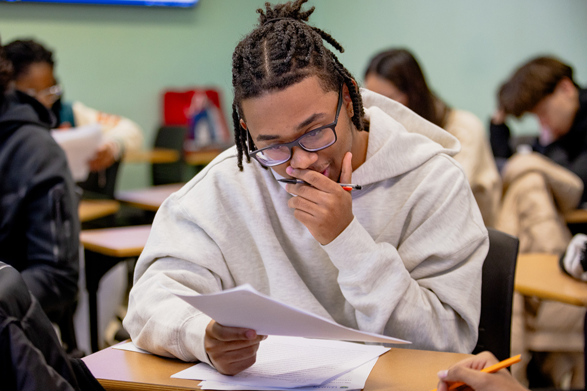 Photo of student looking at paper in classroom