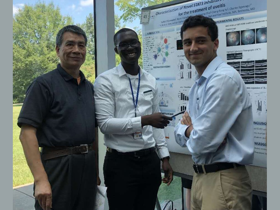 Ezekiel Olumuyide, pictured center, worked with National Institute of Health staff scientist 
Dr. Cheng Rong-Yu, left, during an internship last year.