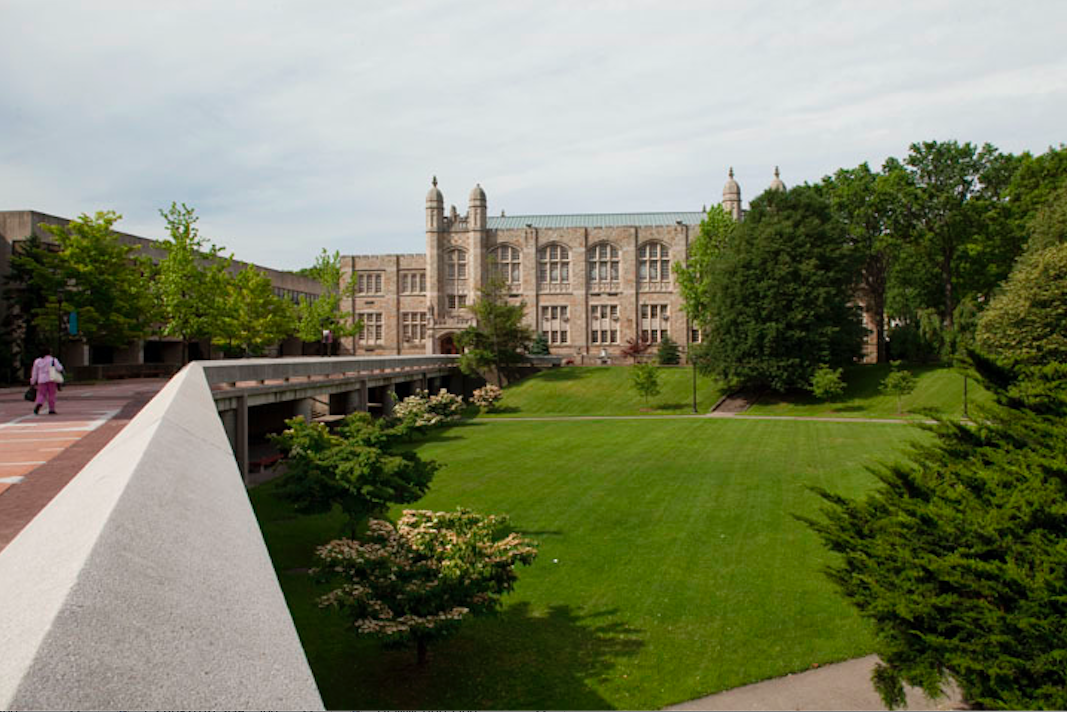 Phtograph of Lehman campus and quad with a neo-Gothic building in the distance.