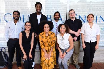 A group of students and an advisor stand in a group facing the camera.