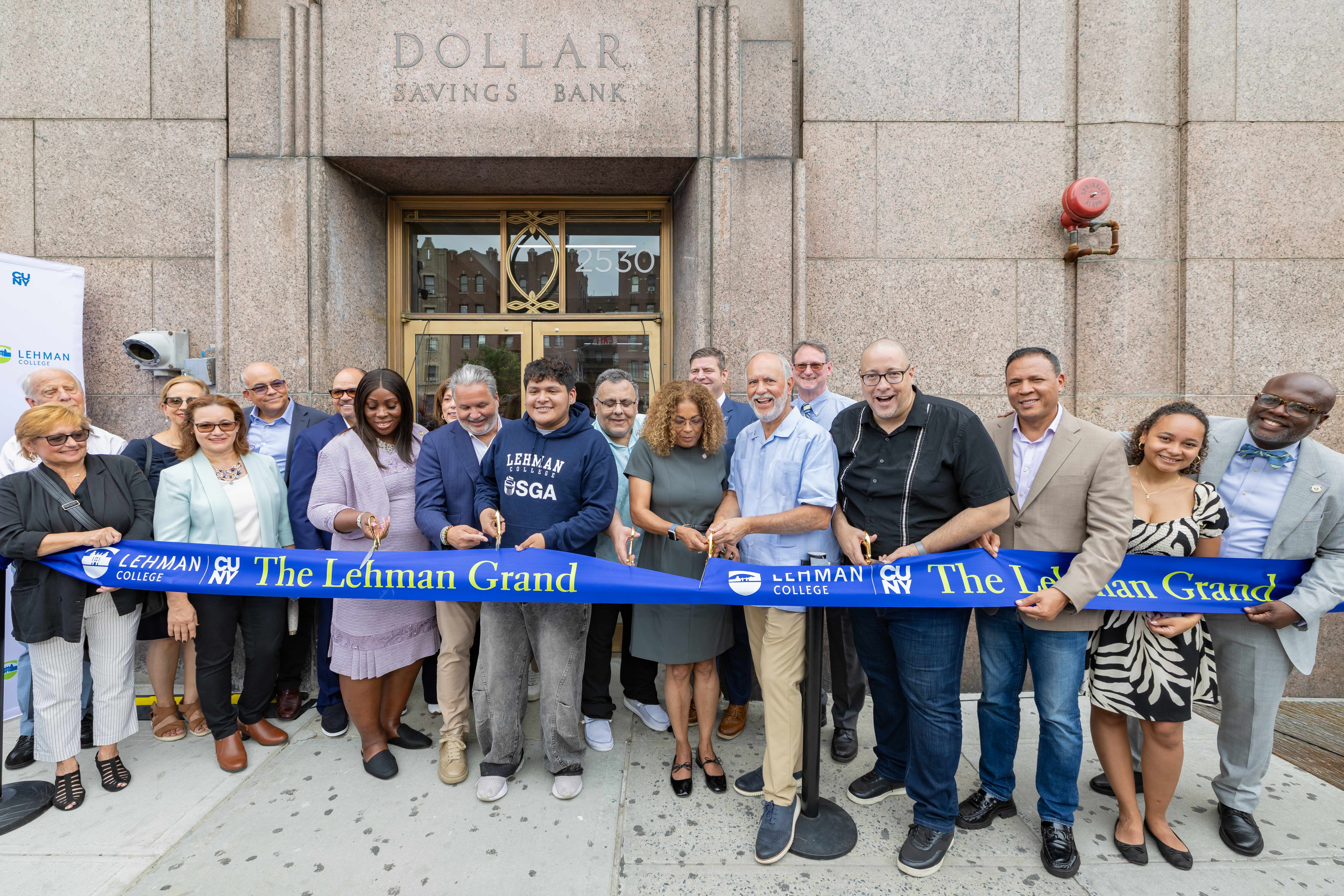 A group of university leaders and members of the Lehman community cut a ribbon for the opening of the student dormitory.