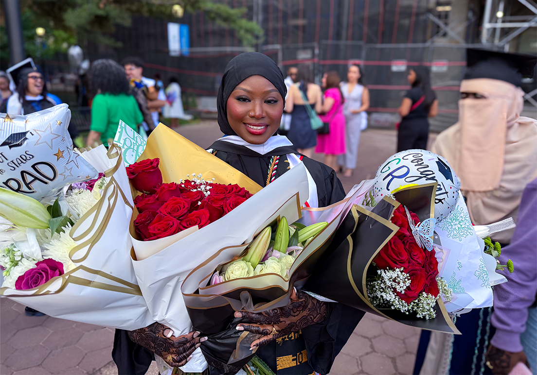 2026 graduate holds four bouquets
