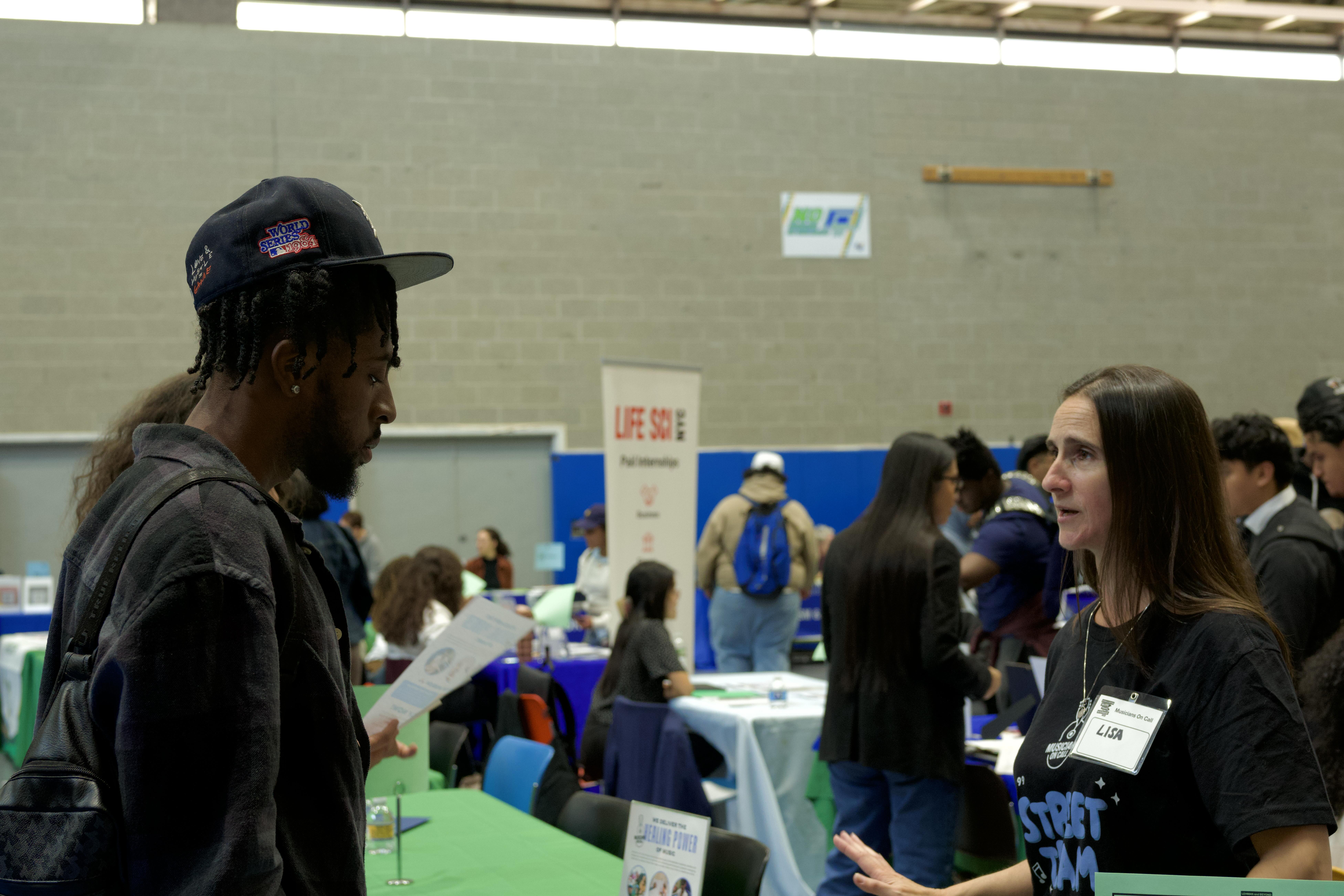 A student speaks with a representative at the majors, minors, and internship fair.