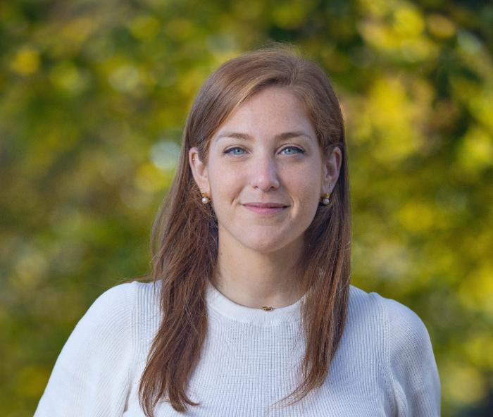head shot of a woman with long hair and a white tee shirt.