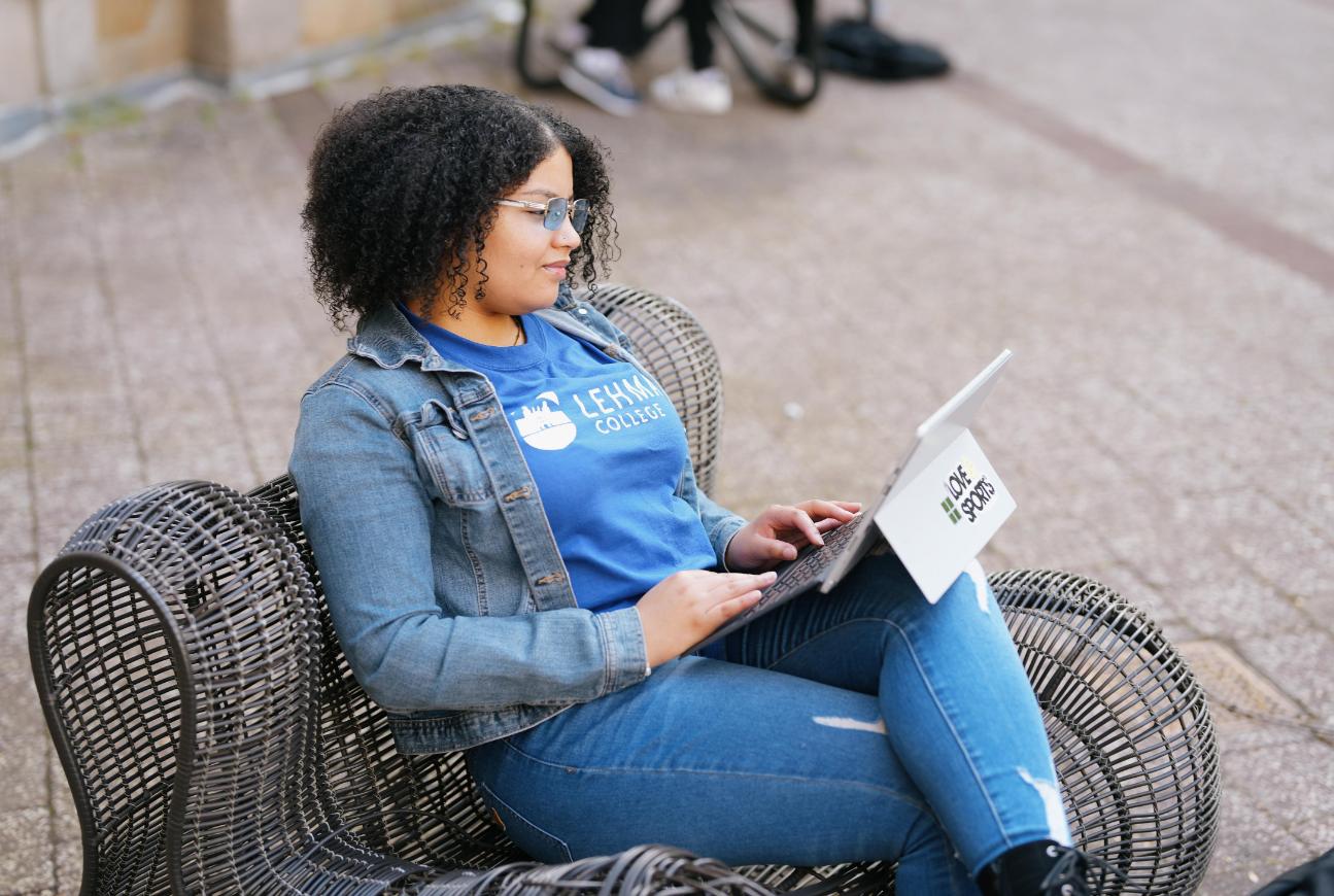 Student sitting on campus looking at computer