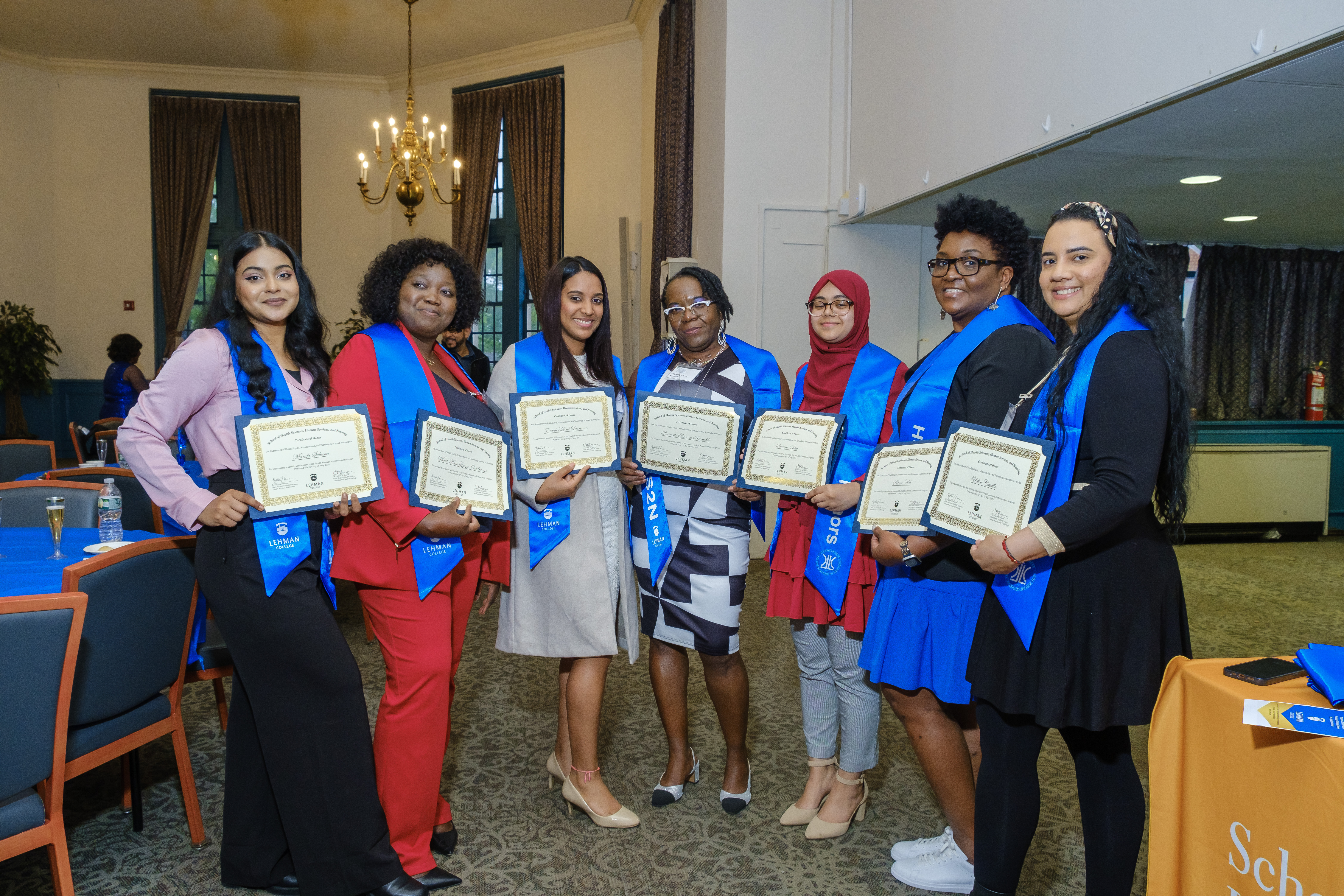 A group of HEAT graduates posing with their honors certificates and stoles.