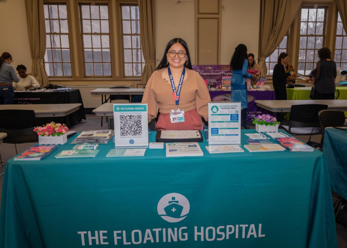 Person in front of table at Health Summit
