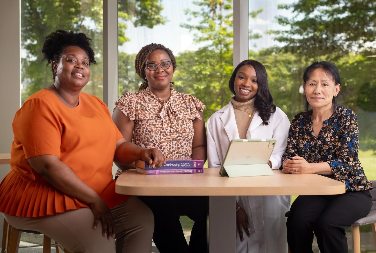 Nursing Graduates sitting together at a table smiling