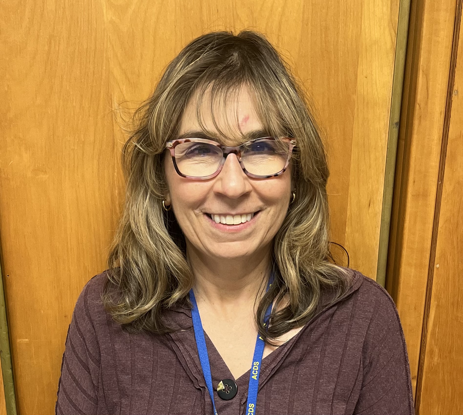 A woman smiling at the camera in glasses