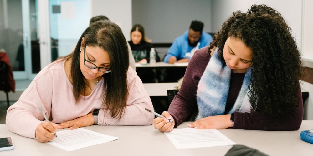 Two Student taking notes in class